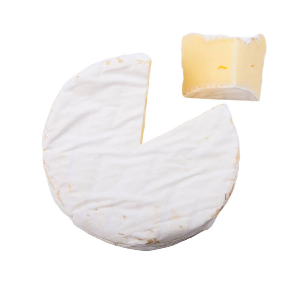 A brie cheese set at an angle with a triangular section cut out - Foto, afbeelding