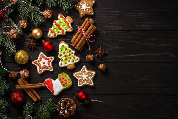 Christmas gingerbread cookies with spices on dark wooden table. Homemade christmas food. Top view with copy space. - Fotoğraf, Görsel