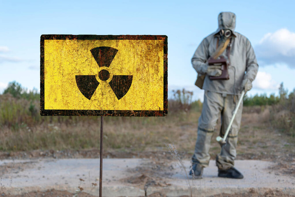 Antiguo signo textural de peligro de radiación, reconocimiento químico militar mide el nivel de radiación contra el fondo de la naturaleza contaminada. - Foto, imagen
