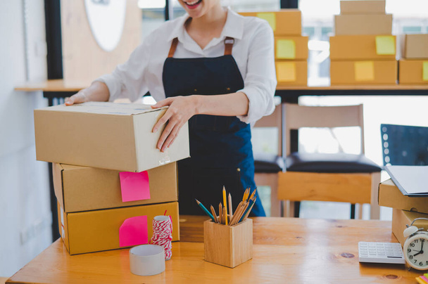 Online small business owners are packing their ordered products into the boxes for their customers based on the concept of online shopping - online shopping. - Foto, immagini