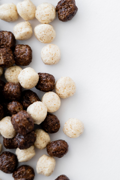 close-up zicht op granen ballen met vanille en chocolade smaken in kom geïsoleerd op wit  - Foto, afbeelding