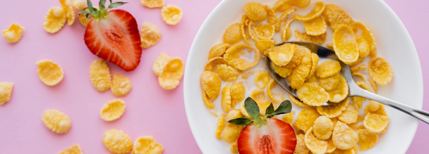 top view of bowl with corn flakes and organic strawberries on pink background, banner - Foto, immagini