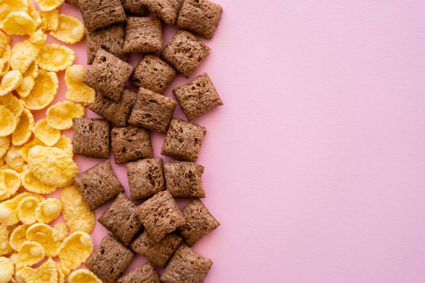 flat lay of breakfast cereal puffs and crispy corn flakes isolated on pink  - Foto, imagen
