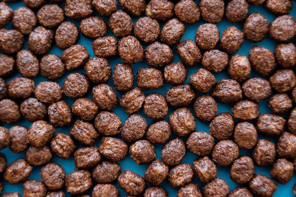 top view of tasty cereal balls with chocolate flavor on blue - Foto, Imagem
