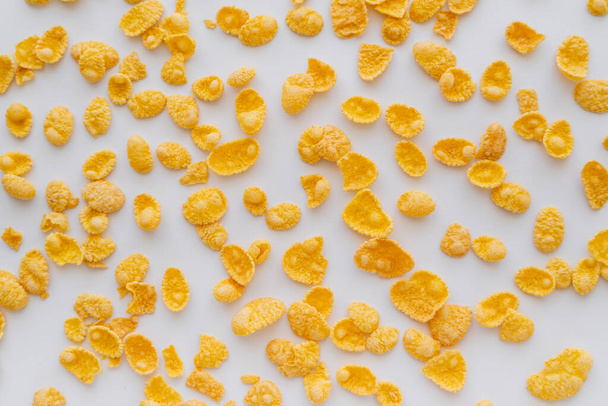 top view of crispy and yellow corn flakes on white background  - Zdjęcie, obraz