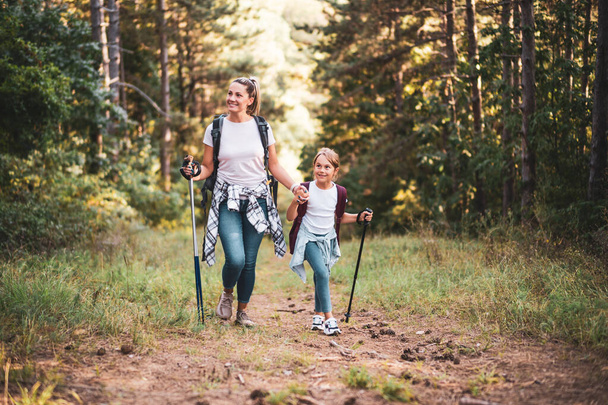 Mother and daughter enjoy hiking together. - Фото, изображение