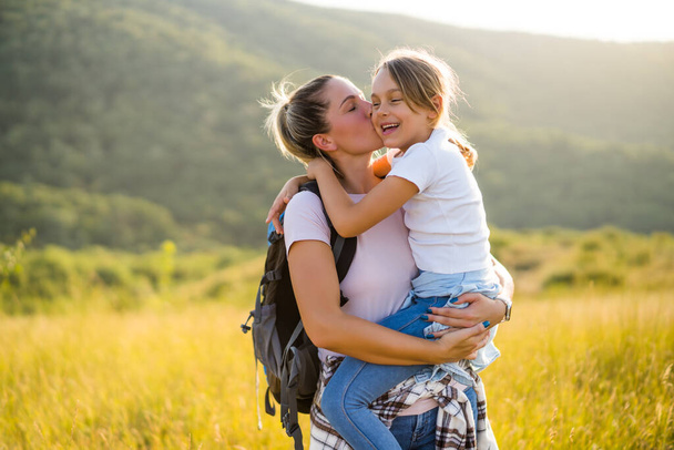 Happy mother and daughter enjoy spending time together in nature. - Zdjęcie, obraz