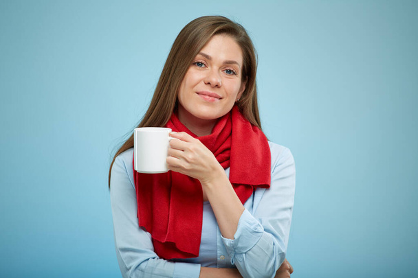 young woman holding white cup with tea or some drink. sick girl wearing red scarf. isolated female portrait. - Fotoğraf, Görsel