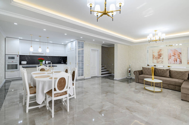 Luxurious large domestic kitchen with marble floor, dining table and sofa - Zdjęcie, obraz