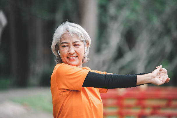 Elderly, white-haired Asian woman exercising in the park early in the morning. - Foto, afbeelding