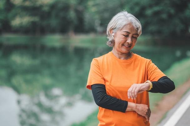 Elderly, white-haired Asian woman exercising in the park early in the morning. - Φωτογραφία, εικόνα