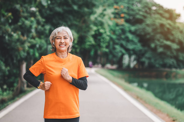 Elderly, white-haired Asian woman exercising in the park early in the morning. - Fotografie, Obrázek