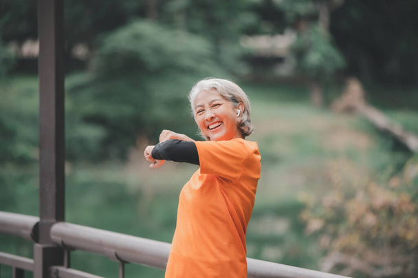 Elderly, white-haired Asian woman exercising in the park early in the morning. - Photo, Image