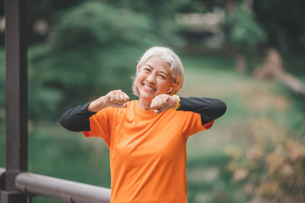 Elderly, white-haired Asian woman exercising in the park early in the morning. - Zdjęcie, obraz