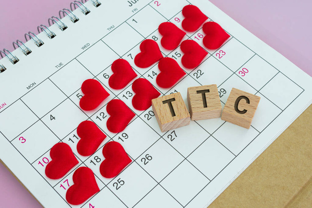 TCC word on wooden block with red heart shape on calendar. Surviving the Two Week Wait when you're trying to conceive. - Foto, Imagem