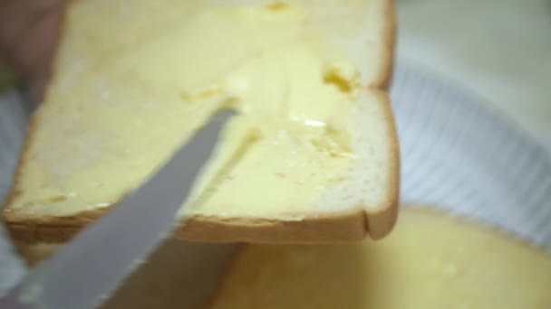 closeup video spread fresh butter on the toasted sliced bread for breakfast healthy meal. Southeast asia breakfast life - Filmati, video