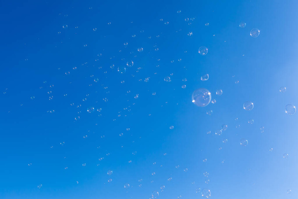 Lot of soap bubbles floating at blue sky - Фото, зображення