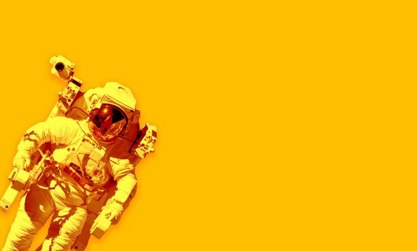 Space suits isolated on yellow background. Elements of this image furnished by NASA. - Fotografie, Obrázek