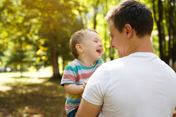 Papa spielt mit seinem kleinen Sohn im Park im Freien. Familienzeit. Glücklich lächelnde Menschen. Junge von eineinhalb Jahren. Kleinkind. Selektiver Fokus - Foto, Bild