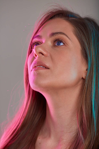 woman looking up, face beauty portrait with multicolored light. natural skin and long hair. - Φωτογραφία, εικόνα