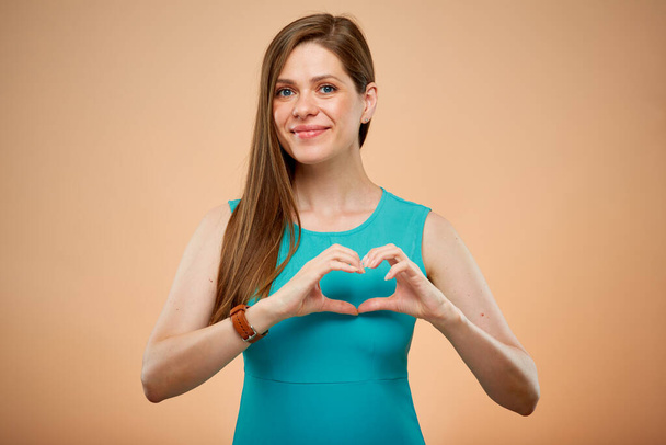 Smiling woman in azure green dress doing heart gesture isolated portrait. Young lady with long hair. - Fotografie, Obrázek
