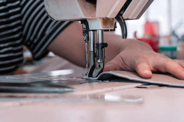 Швея шьет швейную машинку, нанизывает нити на ткань. Женские руки - Фото, изображение