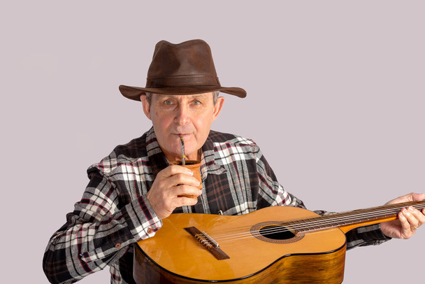 old man with guitar and the typical infusion in Argentina and Uruguay called Mate - Foto, Imagen