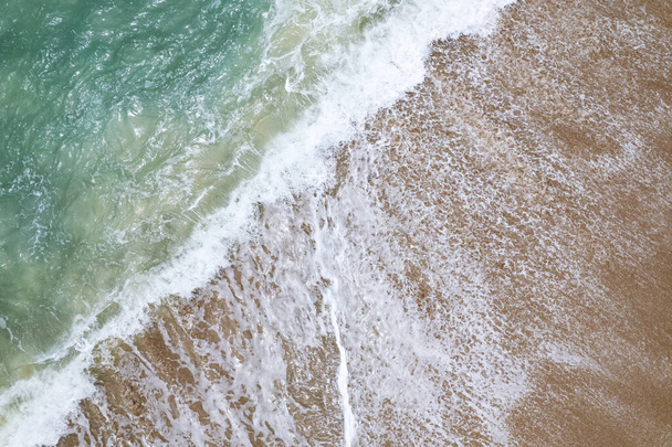 Luftaufnahme Wellen krachen auf Sand von Strand und weichen Wellen Hintergrund, Draufsicht - Foto, Bild