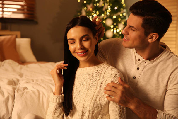 Happy couple in festively decorated bedroom. Christmas celebration - Fotografie, Obrázek