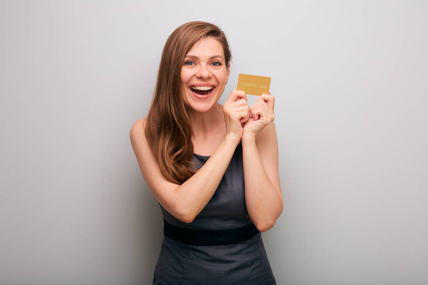 Happy business woman in gray dress with credit card. isolated female business person portrait with mouth open and positive emotion. - Fotoğraf, Görsel