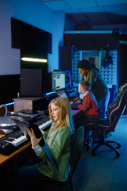 Sound producer with children band in recording studio - Foto, afbeelding