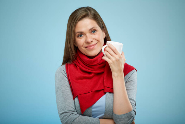 smiling woman holding white mug. sick but happy girl in red scarf. isolated female portrait. - Φωτογραφία, εικόνα