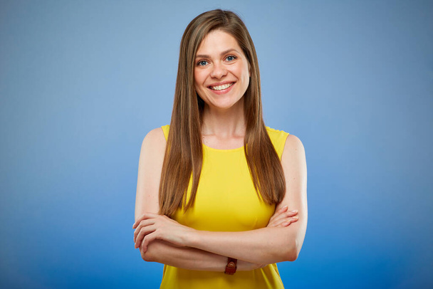Young smiling woman in yellow casual dress. Isolated female portrait on blue background. - Photo, Image