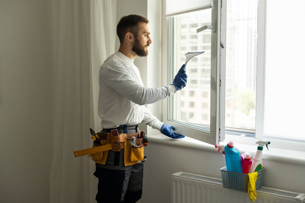 Young man washing window in office - Photo, Image