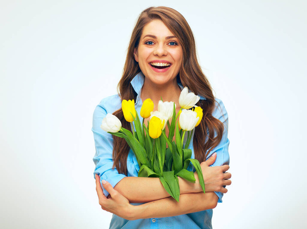 happy smiling woman holding flowers in front of her. isolated female portrait of girl wearing blue shirt. - Foto, immagini