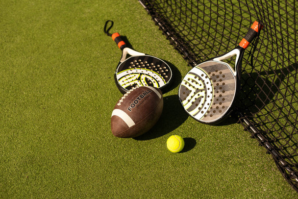 Equipamiento deportivo, raquetas y pelotas en el suelo de la pista. - Foto, imagen