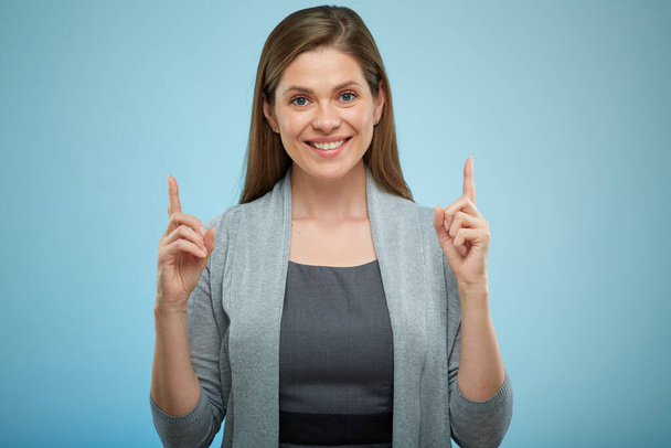 Smiling woman pointing with fingers up, isolated female portrait. - Valokuva, kuva