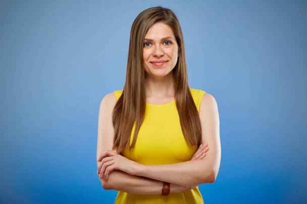 Smiling woman in yellow casual dress. Isolated female portrait on blue background. - Foto, Imagen