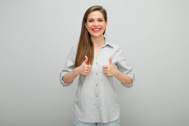 Thumbs up. Smiling woman, isolated female portrait, young lady dressed pants and gray shirt. - Φωτογραφία, εικόνα