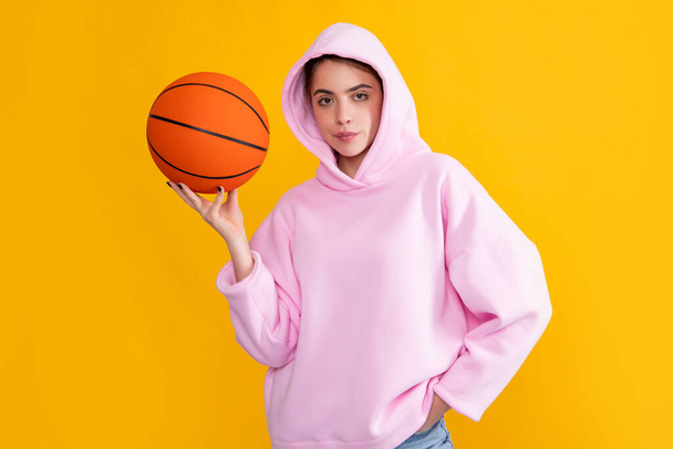 cool sporty girl student with basketball ball on yellow background. - Foto, immagini