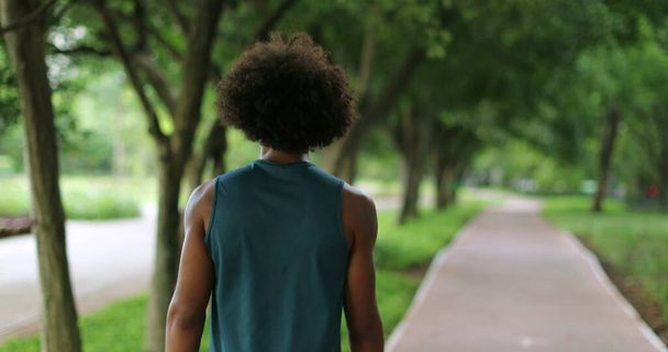 Back of african black man walking in nature pathway park - Photo, image