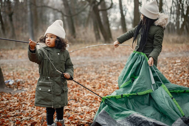 Beautiful little black girls in tent camping in the forest. - 写真・画像