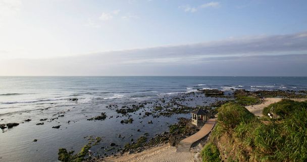新北市石門の岩浜に海の波が打ち寄せる - 写真・画像