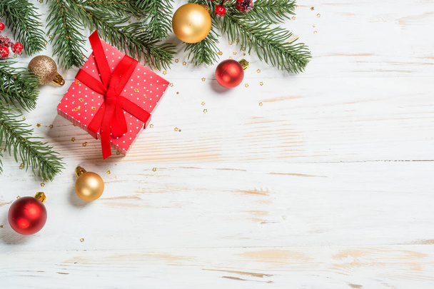 赤いリボンと休日の装飾が施されたクリスマスプレゼントボックス。白木のテーブルの上からの眺め. - 写真・画像