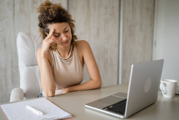 Una giovane donna d'affari seduta e pensante in ufficio mentre lavorava sul concetto moderno di imprenditrice donna d'affari portatile - Foto, immagini