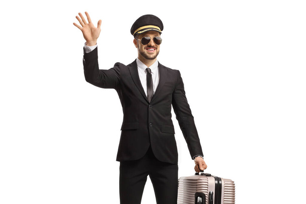 Chauffeur carrying a suitcase and waving isolated on white background - Фото, изображение