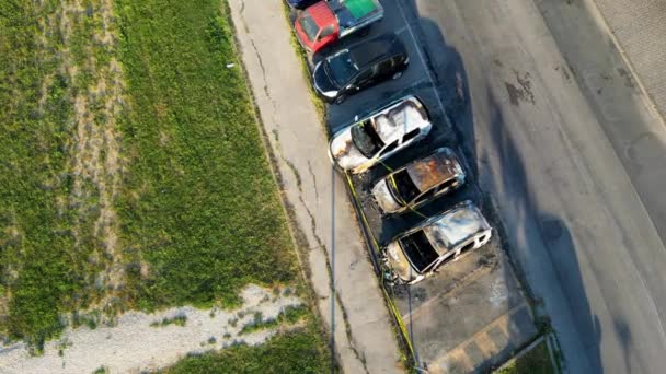 Burned cars in a city parking. Vandalism concept, aerial view drom drone - Materiał filmowy, wideo