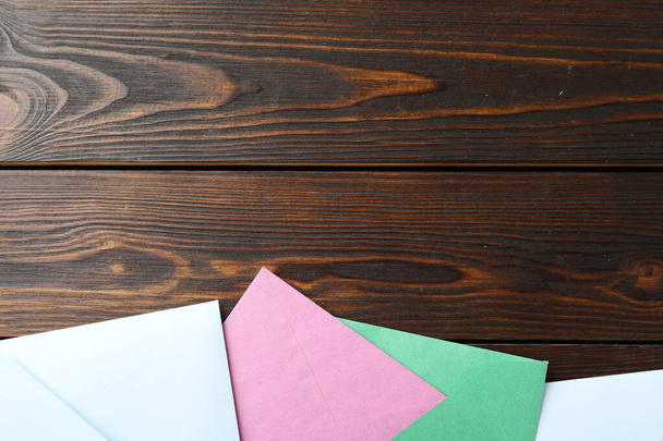 Colorful paper envelopes on wooden background, flat lay. Space for text - Valokuva, kuva