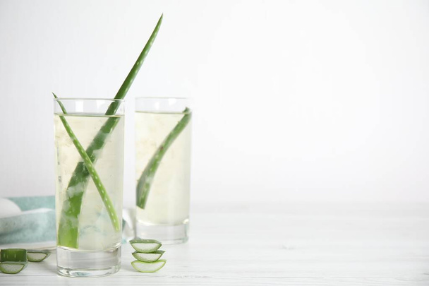 Čerstvý aloe drink s listy v brýlích na bílém dřevěném stole. Mezera pro text - Fotografie, Obrázek