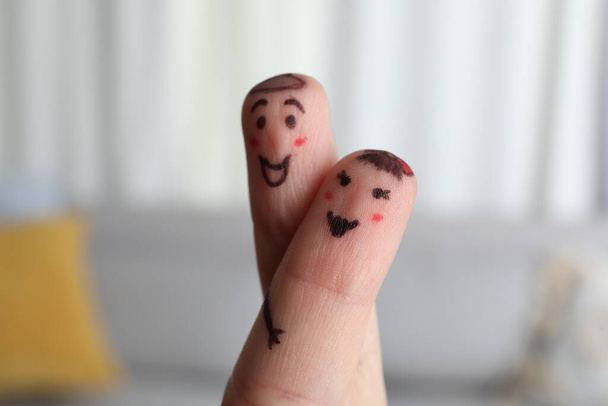 Two fingers with drawings of happy faces on blurred background. Spending time together - Valokuva, kuva